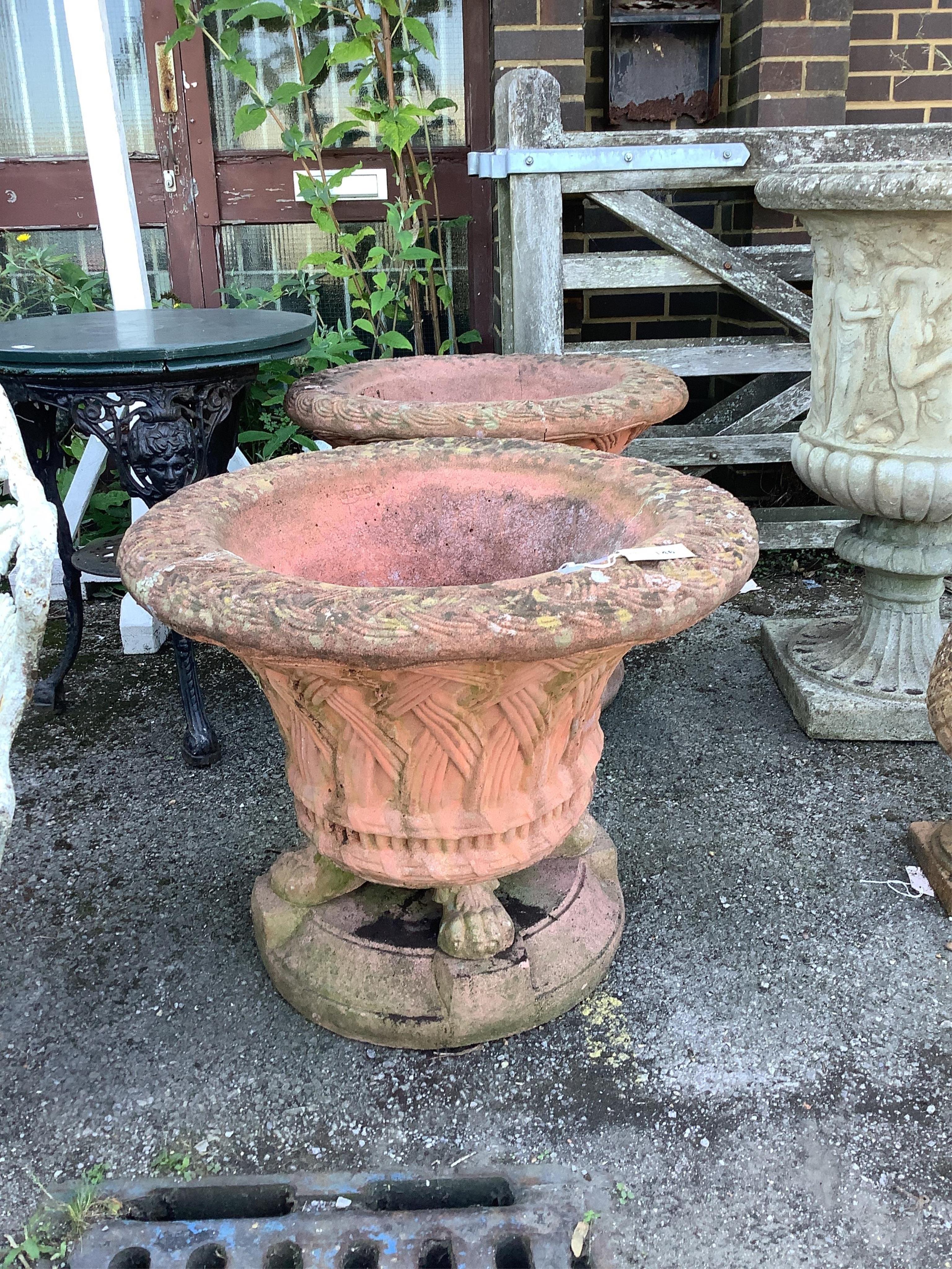 A pair of circular terracotta garden urns with basket weave bodies on lion's paw feet, diameter 72cm, height 60cm. Condition - poor to fair